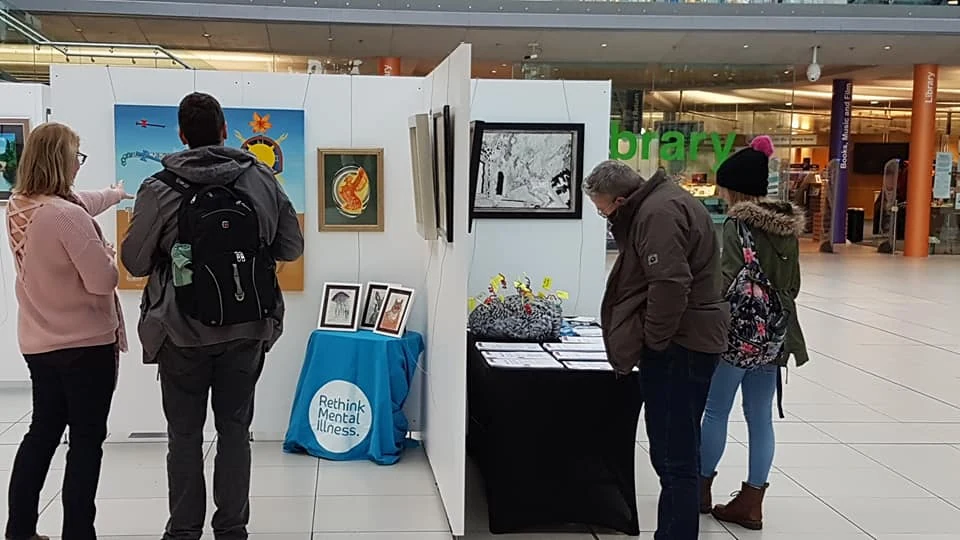 Visitors looking at the work